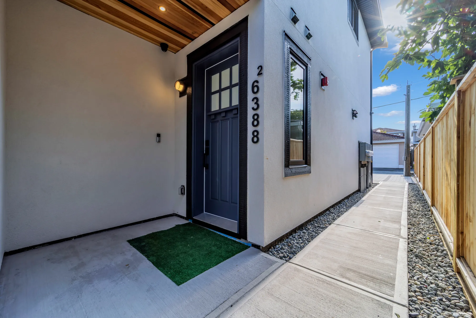 The front door of unit 2 under a cedar soffit, the address beside it