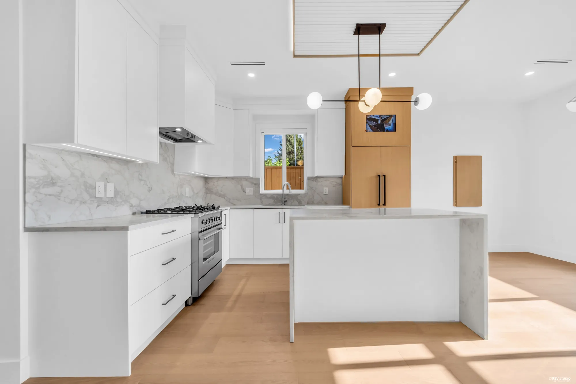 Galley kitchen with the waterfall island and gas range